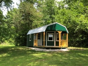 Green shed in woods on gravel pad