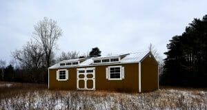 Brown shed with snowy roof