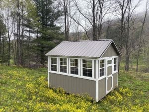 gray greenhouse shed in field of flowers