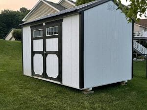 white utility shed with black roof