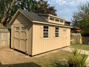 beige shed with black shingle roof