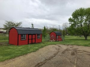 Two red and black barns and a chicken coop
