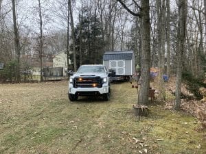 Gray shed being delivered by truck