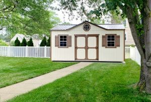 white shed in backyard with brown trim