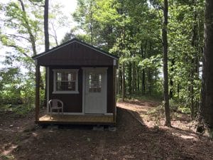 Storage shed with porch in the woods
