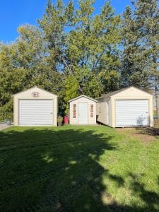 Three beige sheds with garage doors